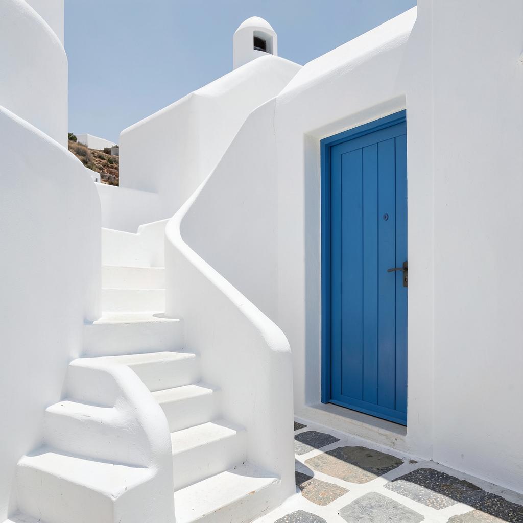 Λευκά σκαλοπάτια και γαλάζια πόρτα μυκονιάτικου ακινήτου